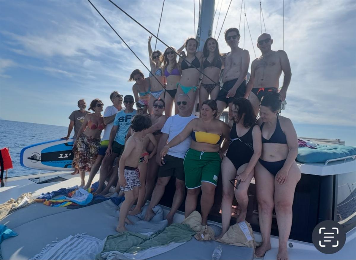 Gruppo di amici festeggia sulle reti del catamarano